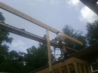 Carpenter setting a ridge beam over a new addition frame — Ice Dam Removal by Roofing Brothers in Stapleton