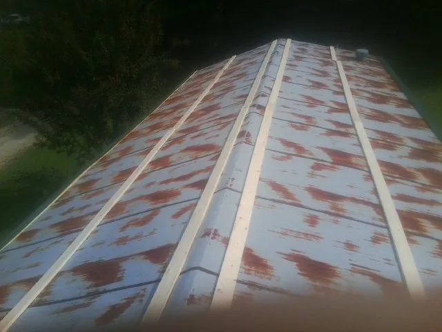Rusted metal roof panels with new wood purlins before replacement — Storm Damage Roof Repair in Stapleton by Roofing Brothers