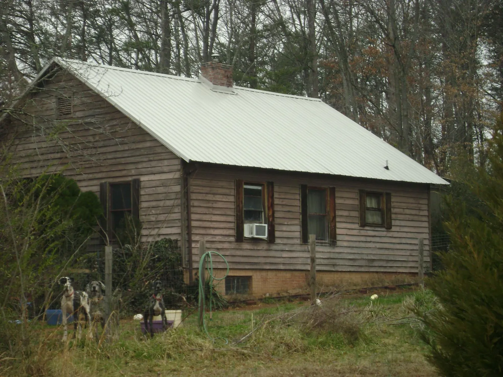 White metal roof on an old wood sided farmhouse, from a Metal Roof Installation job in Stapleton